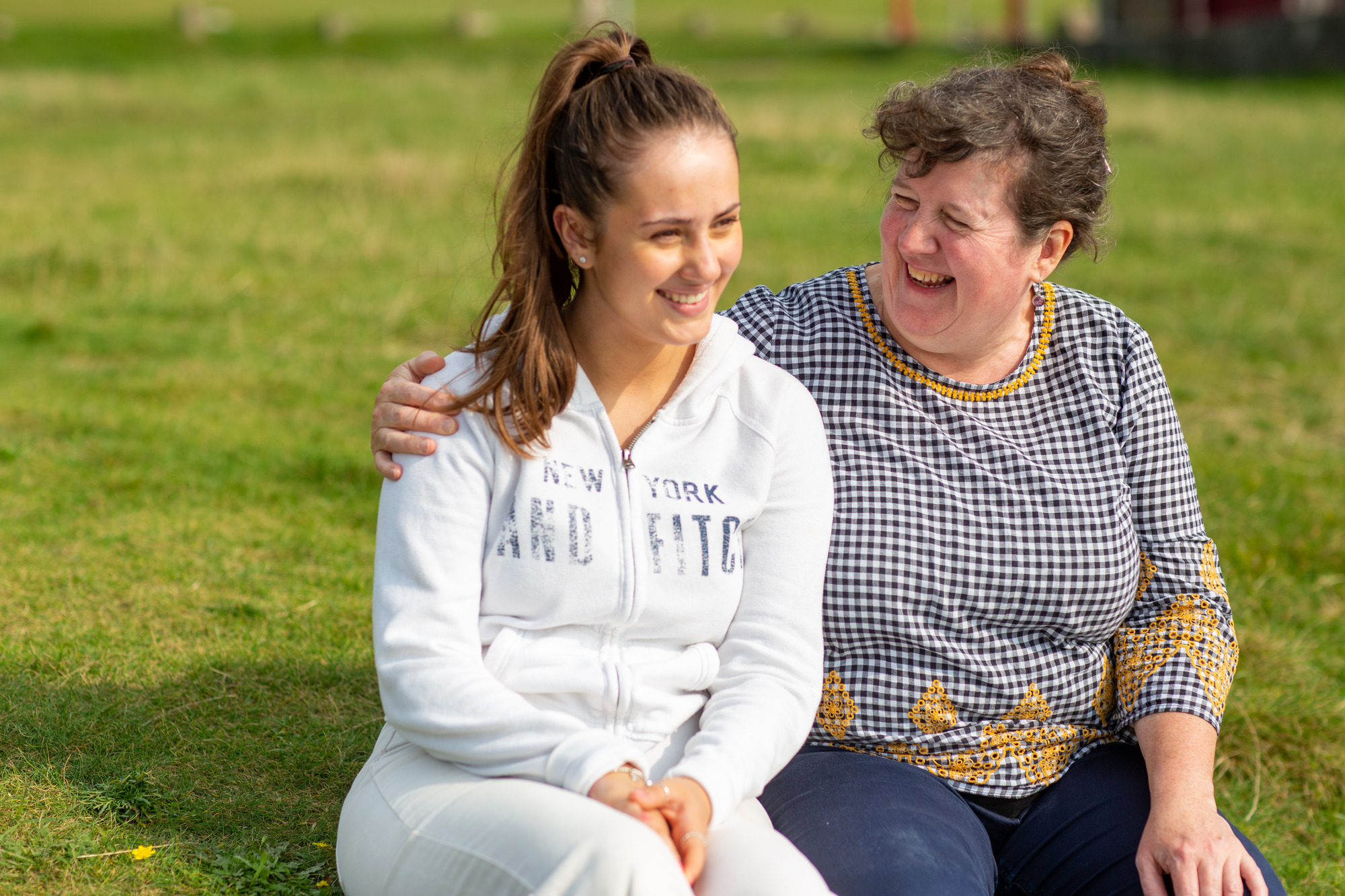 carer and young woman hugging and smiling